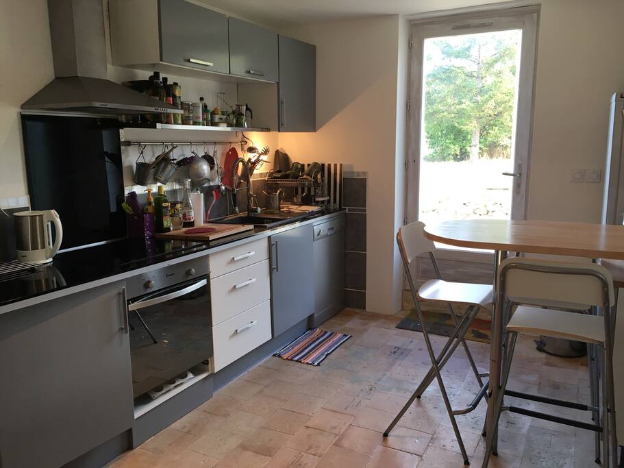 La cuisine équipée avec plaque, four, lave vaisselle, micro ondes, frigo congélateur, bouilloire, grille pain.