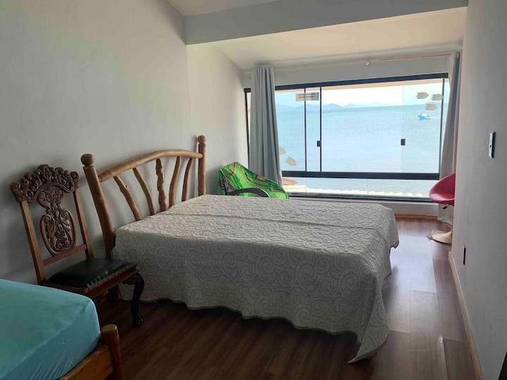 חדר עם מיטה זוגית ומיטת יחיד. Vista para o mar