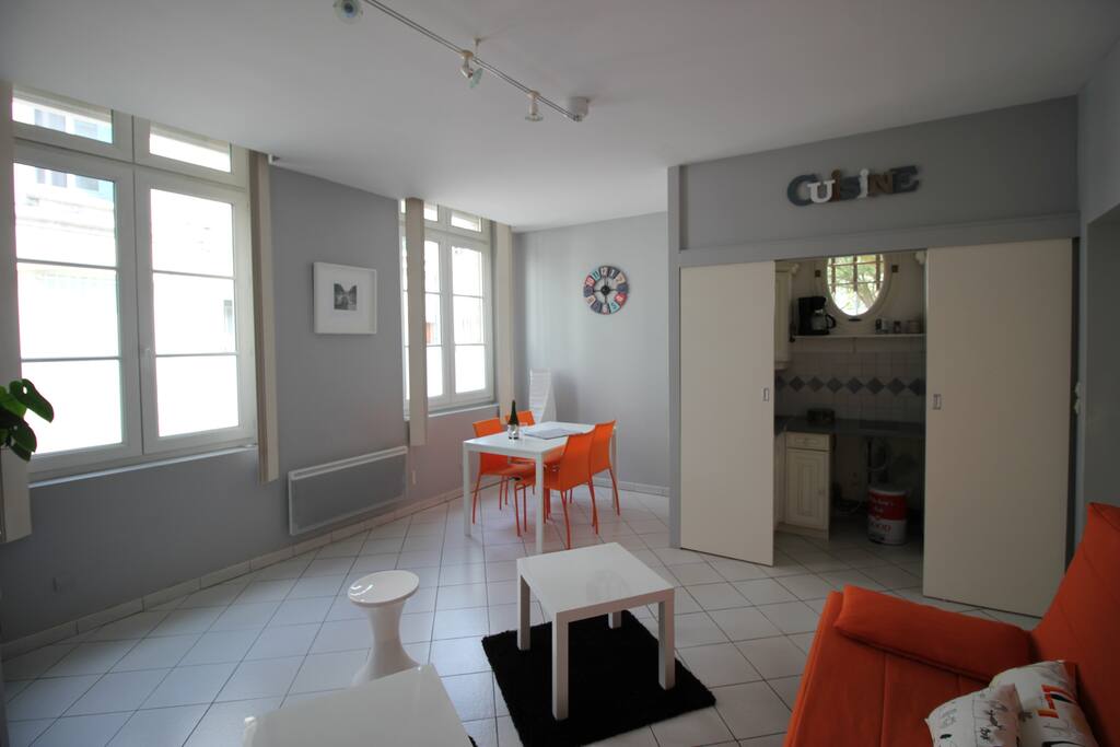 Séjour salon avec vue sur le coin cuisine séparé par des portes coulissantes.