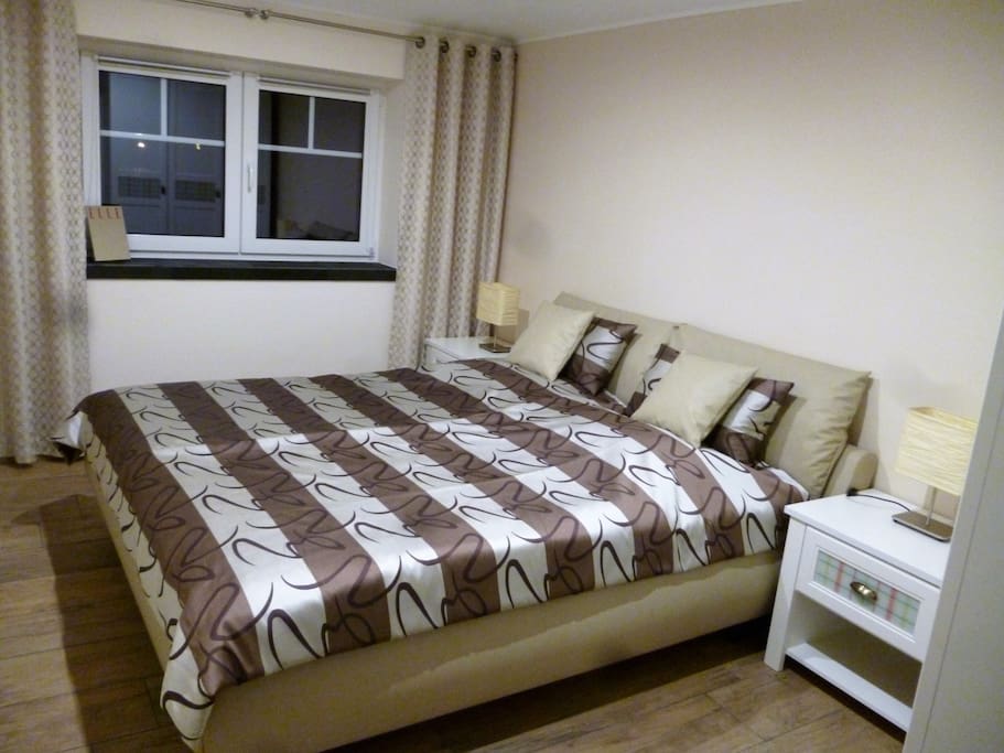 Schlafzimmer mit Doppelbett, Nachtschränkchen und Kleiderschrank.