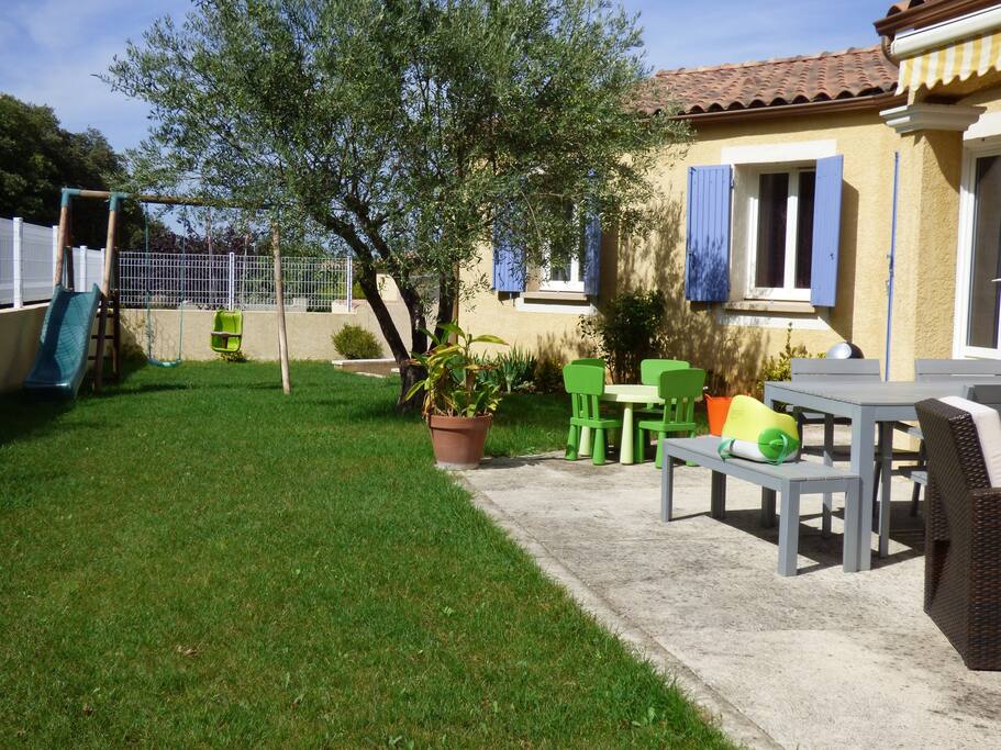 Coin détente à l'extérieur : tables adultes et enfants, portique avec balançoire et toboggan, grand trampoline, jeux extérieurs pour enfants