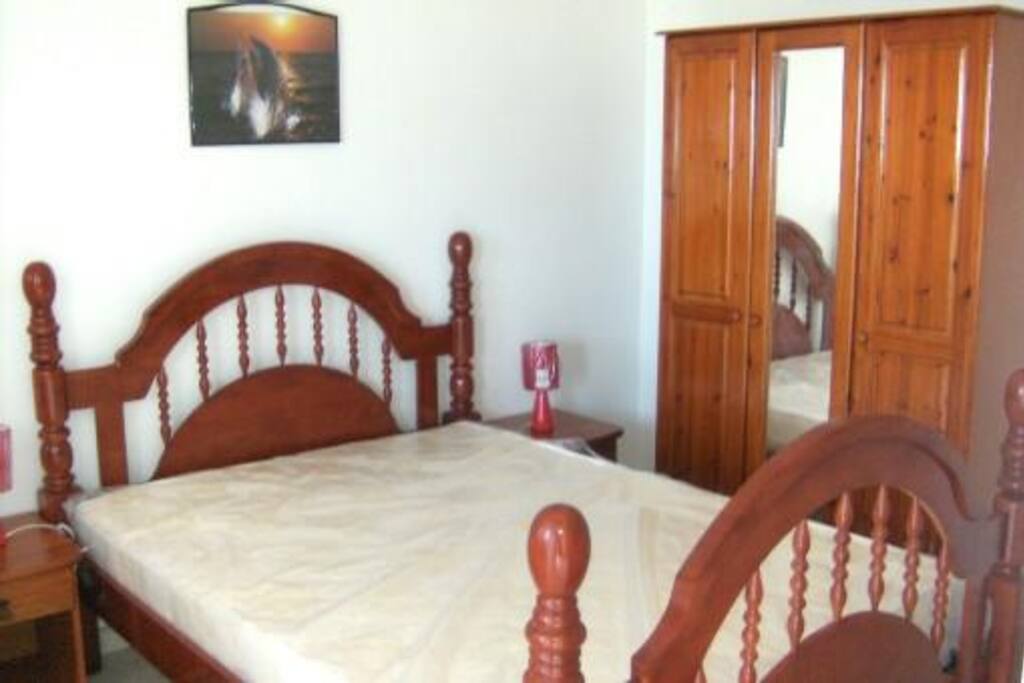 La chambre est composée d'un lit double en bois local avec armoire
