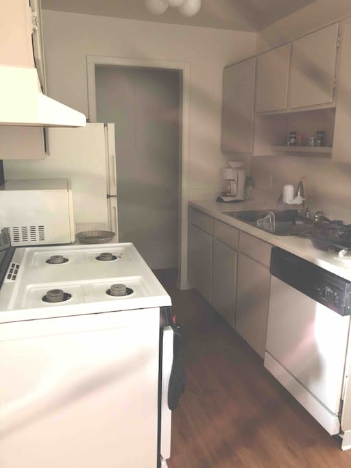 this is the kitchen with a microwave a gas stove and a dishwasher that are available for you to use. feel free to cook here as well also a refrigerator included