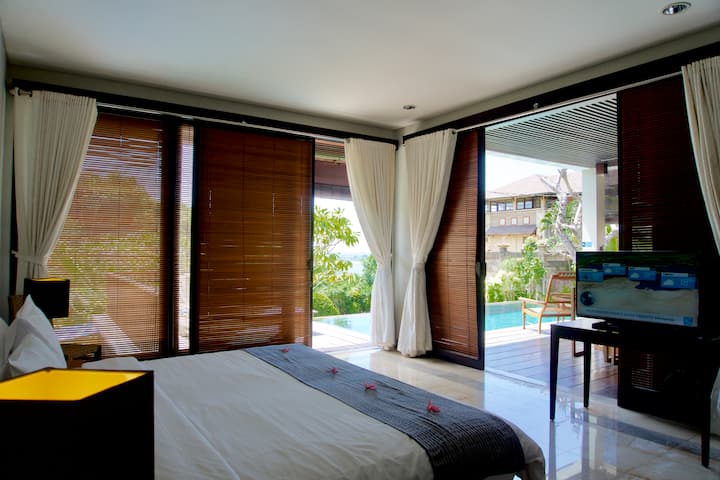 Dhoma e gjumit #1 me pamje të pjesshme nga deti dhe pishina e vendosur në katin përdhes. Mund të vendoset si dhomë dyshe ( 2 krevate tekë)