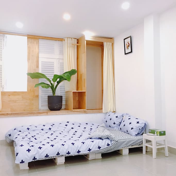 A double sized bed in a cozy private room with a bedside table