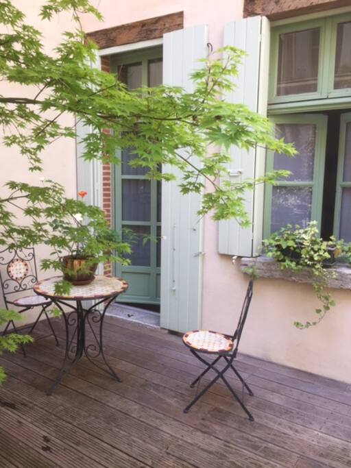 Une table et deux chaises pour prendre vos petits déjeuner à l'extérieur.