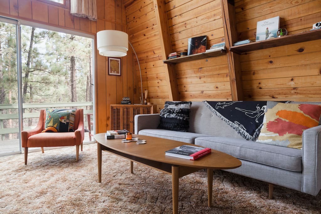 The living room is large and open with floor to ceiling views of the trees that surround the cabin. Seating all around the room is perfect for great talks with even greater people.