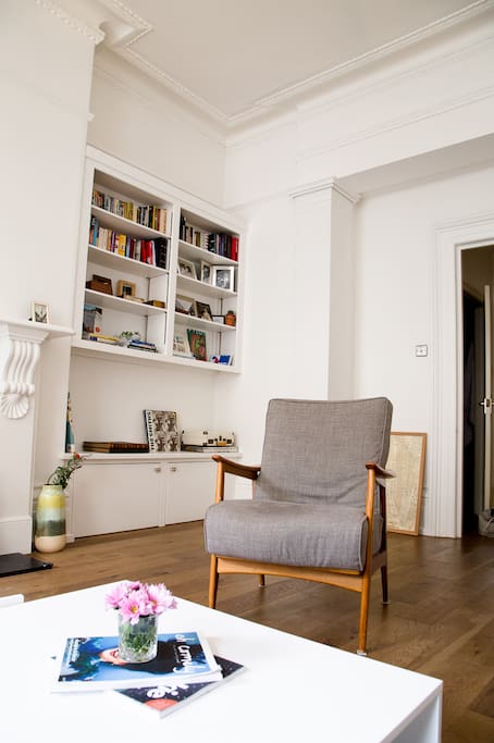Spacious, very bright living room with two large high-ceiling windows, and original wooden shutters