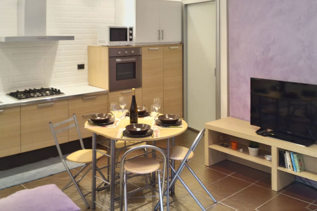 La zona giorno e la cucina con tavolo da pranzo/ Living area with kitchen and dining table