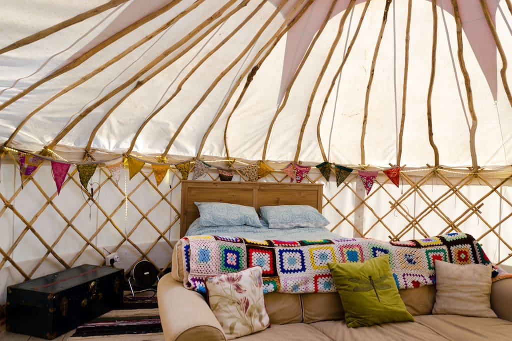 Inside the yurt with king size bed and large sofa for romantic nights in