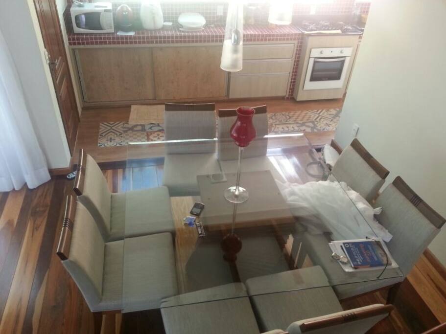 sala de jantar com oito cadeiras. Cozinha estruturada para jantares de negócios.