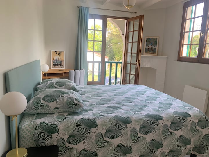 Grønt soveværelse med queensize-dobbeltseng, en balkon 