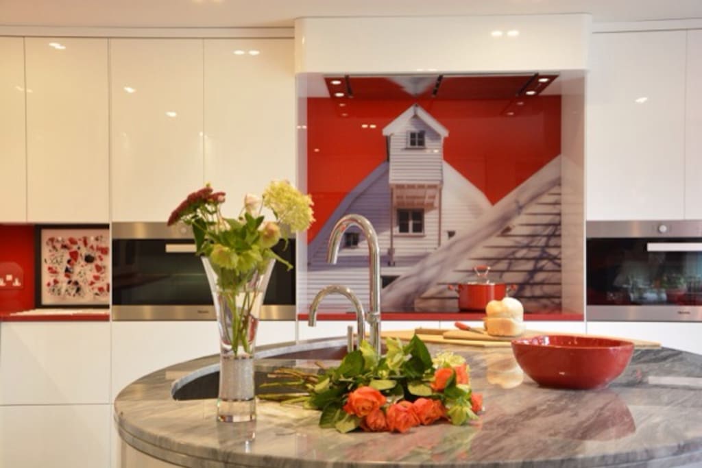 Kitchen - showing the stunning glass splash back image of the mill and is the focal point of the kitchen where the oblong miele hob is and 2 miele wide ovens on either side
an exquisite kitchen to use having everything you should need