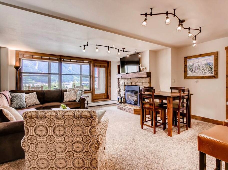 Living room with view of seating, fireplace, flatscreen TV and the Sunroom