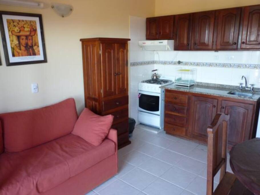 Living comedor con cocina, microondas, heladera con freezer , y TV por cable, y ventilador de techo.