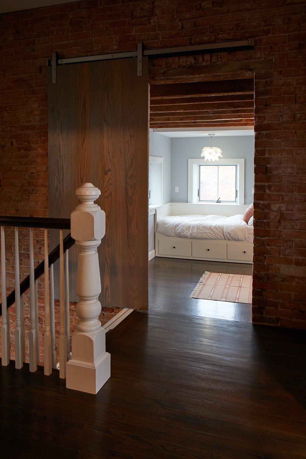 Upstairs to the bedroom behind a sliding barn door with two twin beds