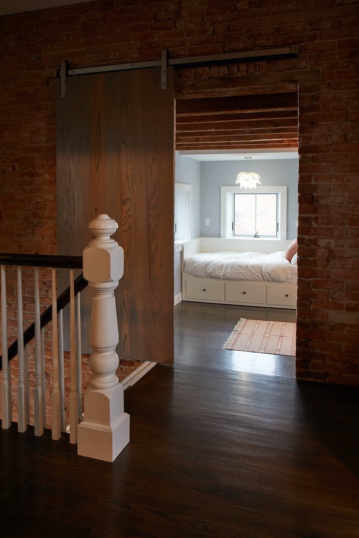 Upstairs to the bedroom behind a sliding barn door with two twin beds
