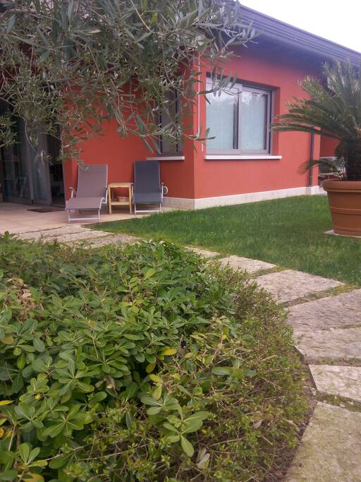 accesso indipendente, porticato vivibile con tavolo da pranzo, divano a dondolo e lettini relax