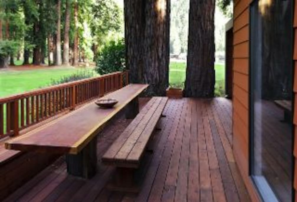 The back patio overlooks a golf course and has a gorgeous long table made of redwood.