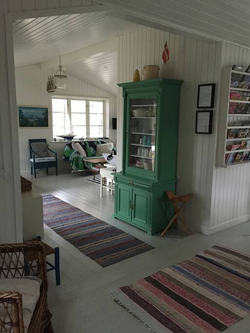 Stuen set fra spisekøkkenet ved brændeovnen.