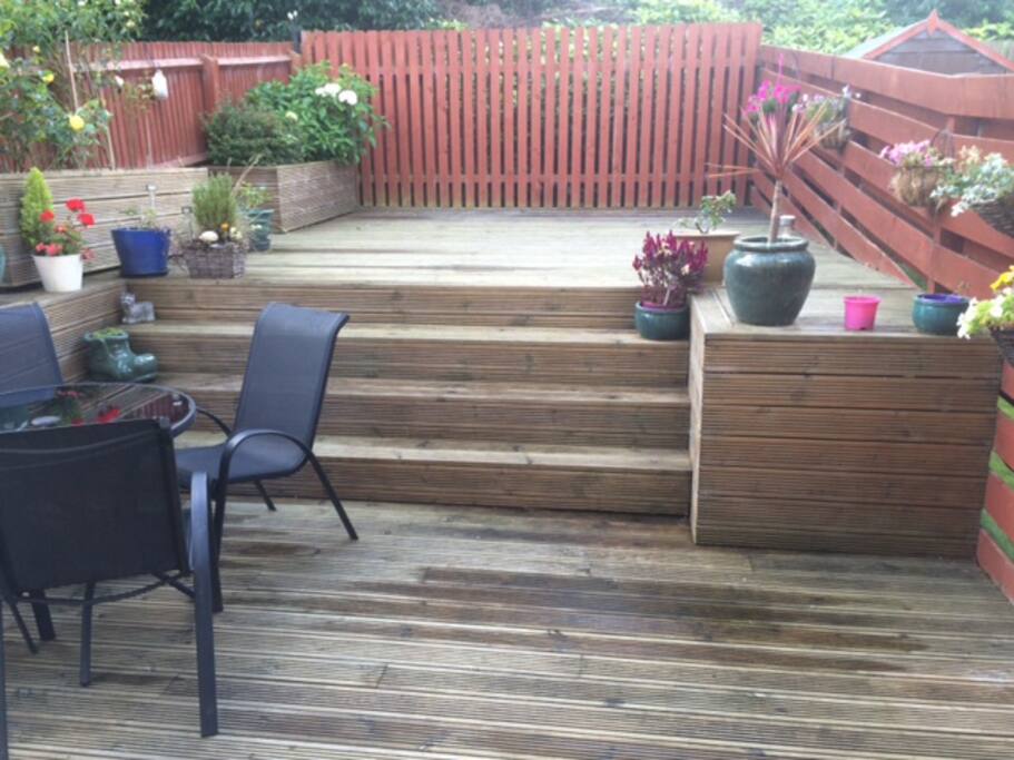 Sunny back garden fully decked with table and chairs