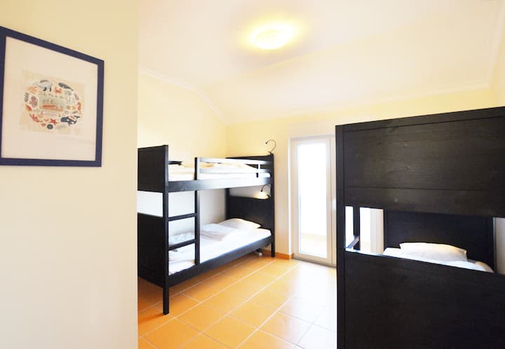 ห้องสีเหลืองเตียงสองชั้นสองเตียงที่เข้าถึงระเบียงได้