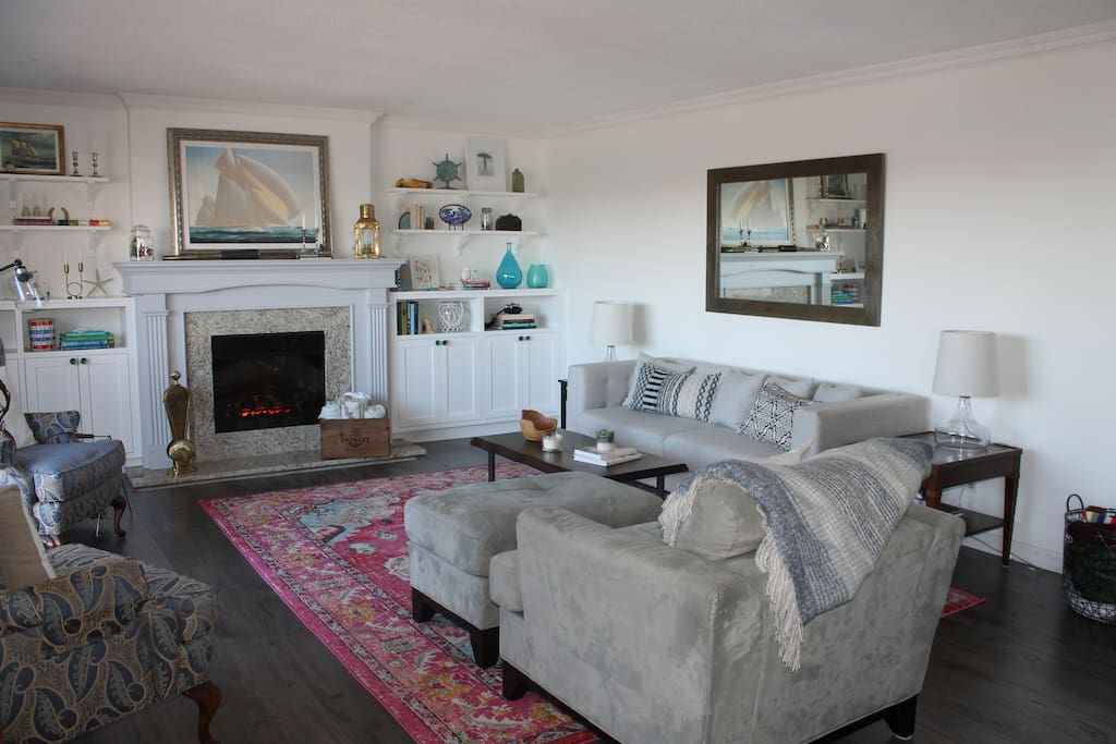 Main floor open concept living room with lots of windows overlooking the water