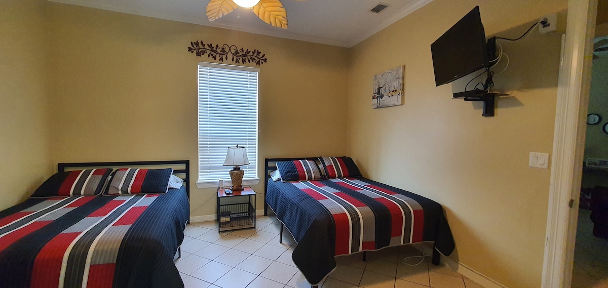 Flatscreen-tv en plafondventilator in de hoofdkamer.