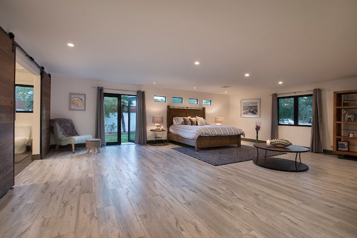 HUGE SECONDARY SUITE BEDROOM WITH CALIFORNIA KING BED AND PRIVATE GLASS DOORS TO THE YARD AND POOL. THE SUITE ALSO HAS ITS OWN PRIVATE ENTRY.