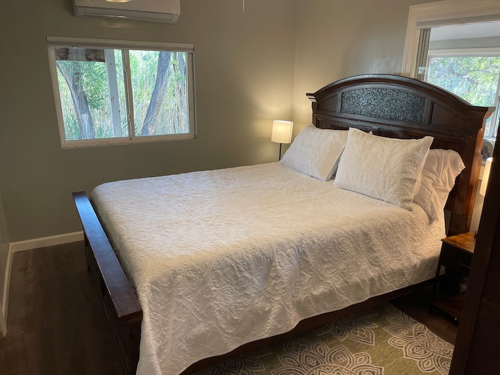 חדר שינה ראשי עם מיטת קווין סייז וחדר רחצה פרטי צמוד.