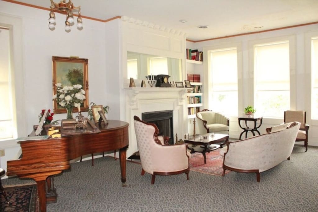 Living room with baby grand and wood fireplace