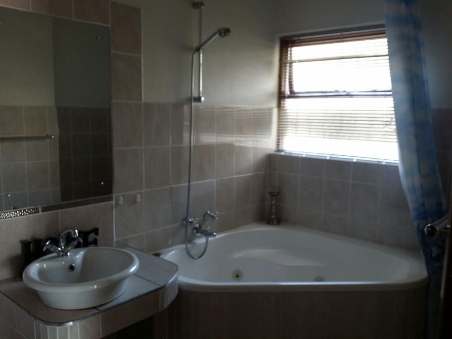 Bathroom with bath and overhead shower