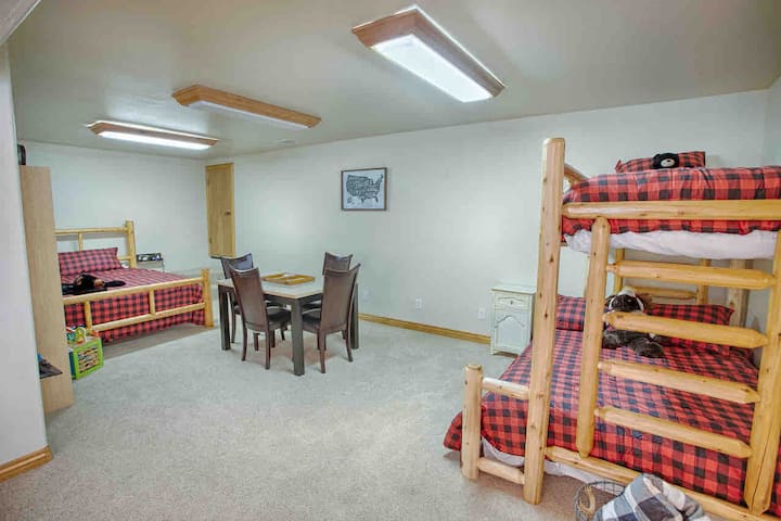 Una cama tamaño king y una litera doble están en esta gran habitación de abajo con baño completo. Esta habitación también tiene una puerta exterior al frente de la casa. 