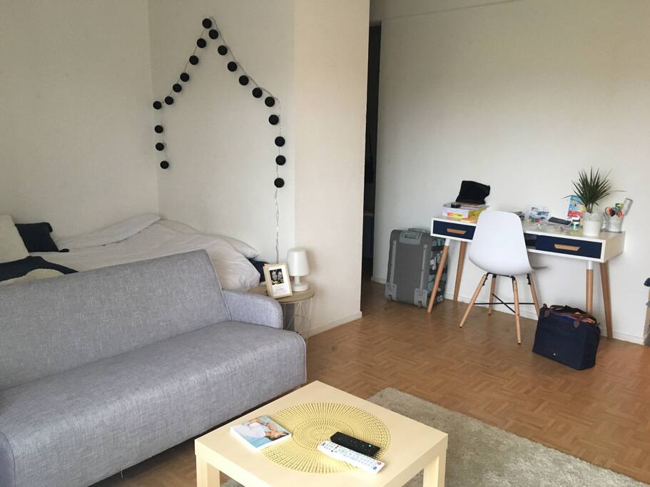 Aperçu du coin chambre et du bureau, derrière le mur avec la guirlande un placard et l’entrée