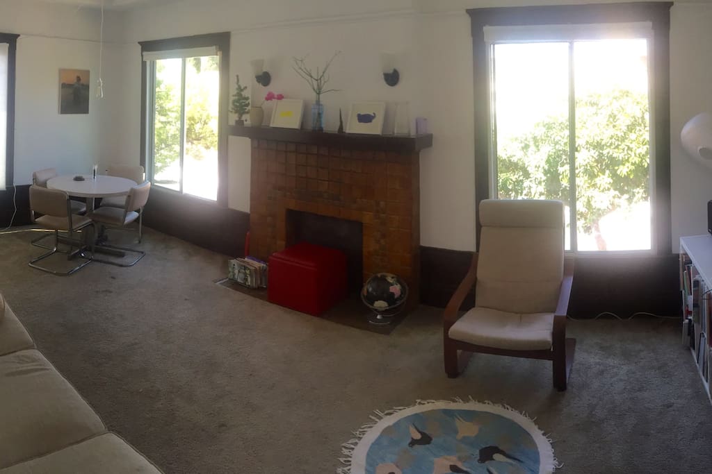 Table for 4, luxury designer couch, interesting fake fireplace, arm chair, sunset views at dusk.