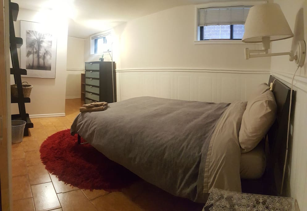 Bedroom with open closet, dresser, shelving and double bed.