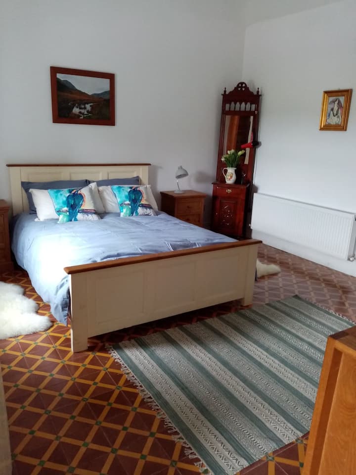 Lyxigt sovrum med 14 fots tak och härliga gamla ursprungliga kakelplattor på golvet.  Sängen är en (irländsk storlek) king size 6'3 lång och 5' bred.  