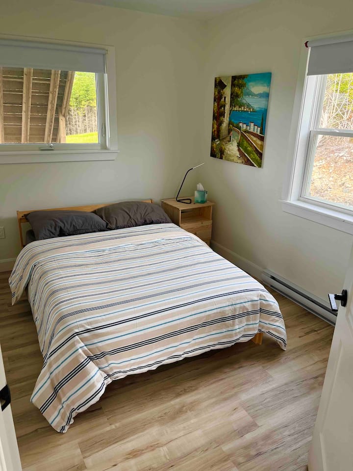 Dormitorio en la planta baja #2 con cama doble y un armario.