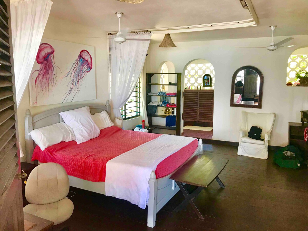 ห้องนอนใหญ่จากประตูระเบียงมองผ่านเตียงไปยังห้องน้ำในตัว