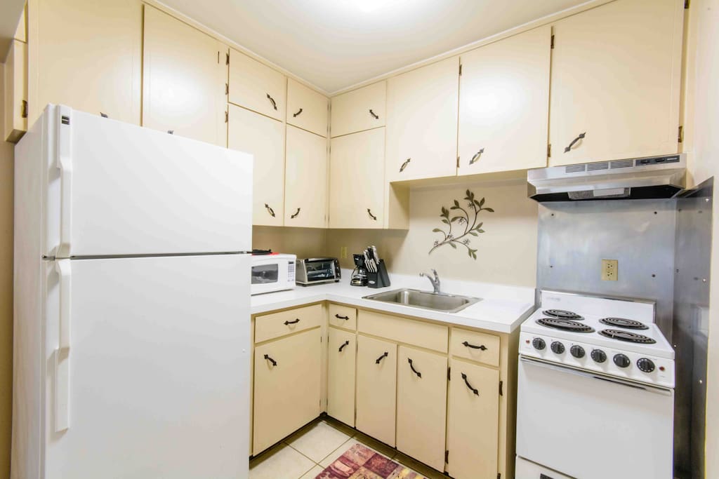 Kitchen showing plenty of cabinet space, electric stove, large refrigerator.