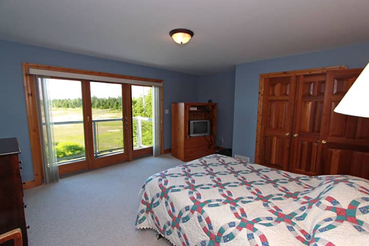 Hlavná spálňa (na druhom poschodí) s vlastnou kúpeľňou. Vychutnajte si výhľad na jazero a posuvné dvere, aby ste vpustili dnu. Budete mať najpokojnejší spánok a budete počúvať zvuky vĺn, ktoré sa valia dovnútra. Predstavte si, že sa tu zobudíte...