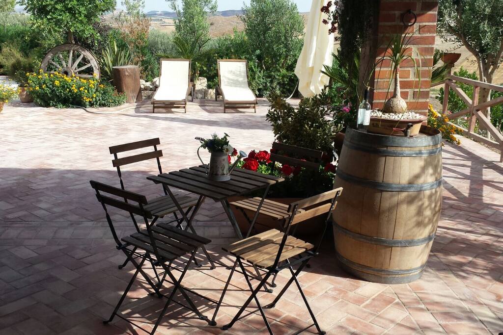 Veranda con tavolino da colazione, dondolo, sdraio e ombrellone per godersi il sole della Sicilia