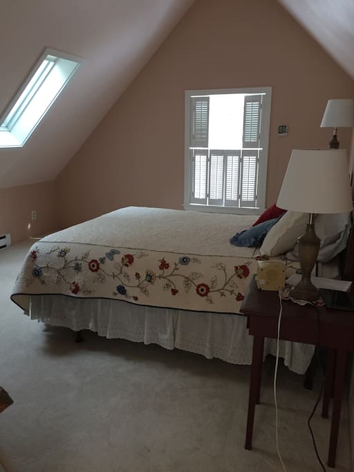 Upstairs spacious bedroom with queen bed and TV.
