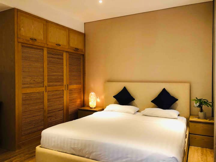 ห้องนอนใหญ่พร้อมเตียงขนาดคิงไซส์และล้อมรอบด้วยหน้าต่างกระจกและระเบียง 