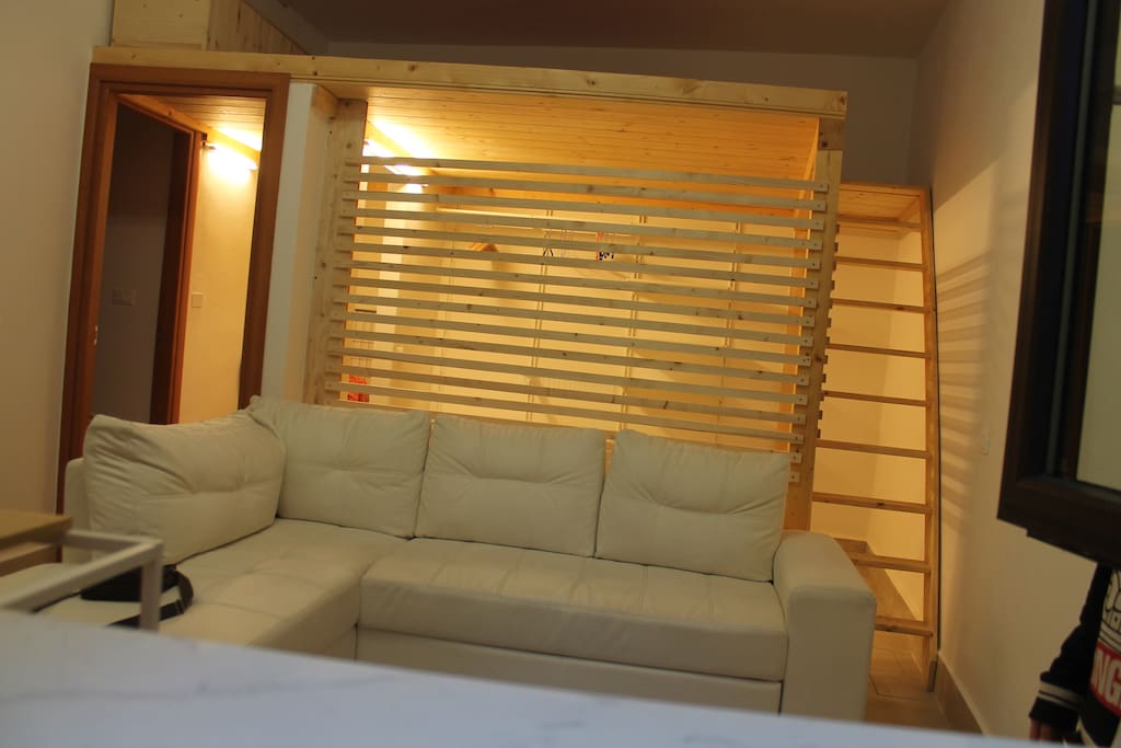 il divano letto e la cabina armadi, con la scala in legno per accedere al soppalco