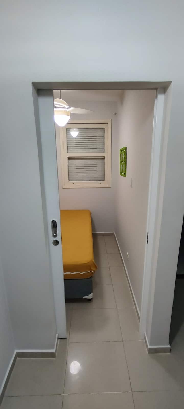 ห้องพักพร้อมเตียงคู่และพัดลมเพดาน ประตูพร้อมกุญแจสำหรับปิดภายใน ตั้งอยู่ที่ชั้นล่าง (หลังจากเข้ามาในอพาร์ทเมนท์) และถัดจาก WC
