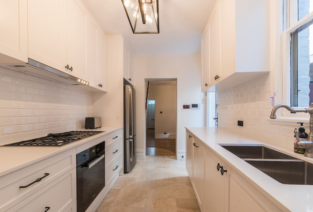 Beautiful kitchen with new appliances and stone floors