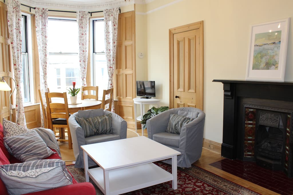 Bright and spacious, West-facing living room with living gas flame Victorian fireplace.