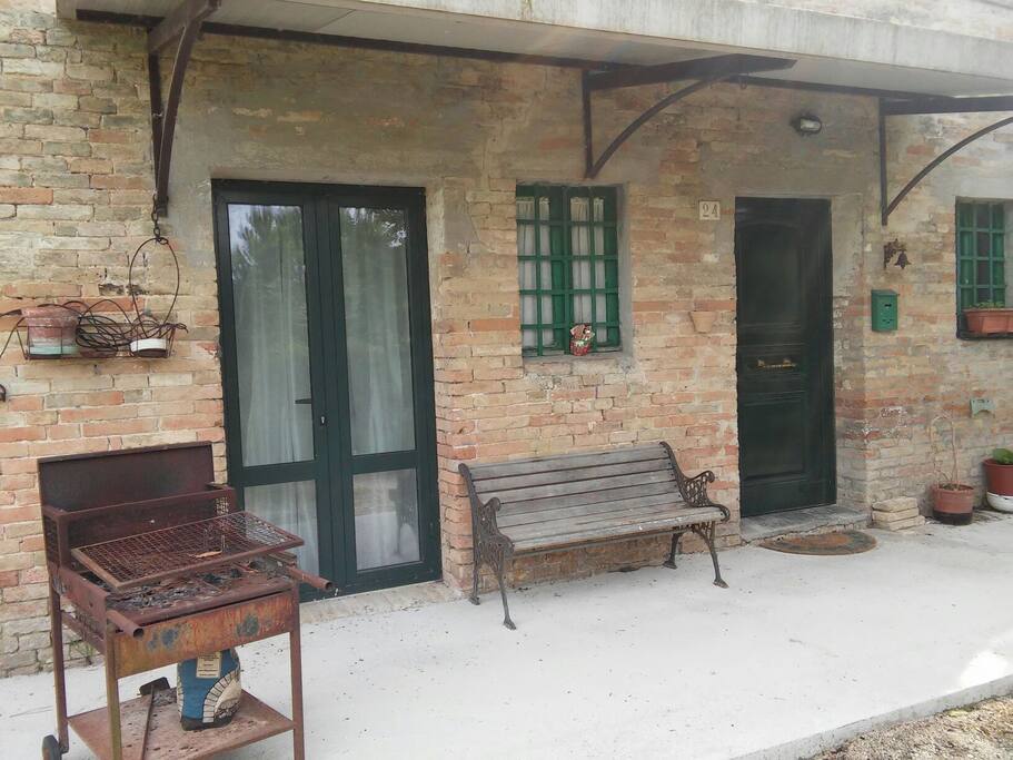 Barbecue e panchina vicino ingresso