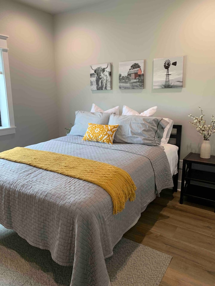 ห้องนอนรองพร้อมเตียงควีนไซส์ Dreamcloud หน้าต่างบานใหญ่สำหรับแสงและโต๊ะข้างเตียงเพื่อความสะดวกสบายของคุณ 